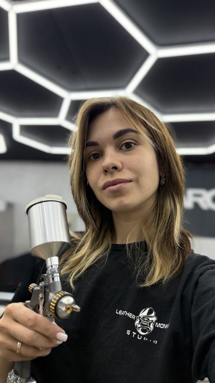 Valeri holding a spray gun in the workshop